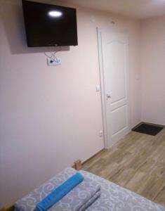 1 dormitorio con 1 cama y TV en la pared en Sobe Spaske en Čačak