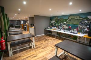 un restaurant avec des tables et une peinture sur le mur dans l'établissement Glen Nevis Youth Hostel, à Fort William