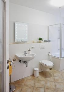ein weißes Bad mit einem Waschbecken und einem WC in der Unterkunft Ferienwohnung Priessnitz in Dresden