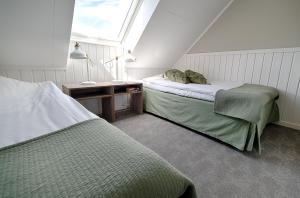 a attic bedroom with two beds and a window at Apelviken Lägenhetshotell in Varberg