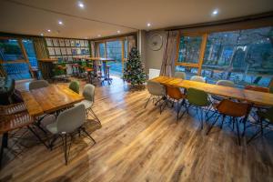 un restaurante con mesas y sillas de madera y un árbol de Navidad en Glen Nevis Youth Hostel, en Fort William