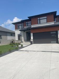 a driveway in front of a house with a garage at Luxury Modern smart home for vacation in Windsor