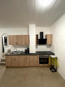 a kitchen with wooden cabinets and a sink in a room at City Apartments direkt am Hauptbahnhof - Perfekt für Pendler und Monteure in Neumünster +136 photos