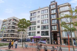 a building on the corner of a city street with people at Julias Rooftop stay in Knokke-Heist