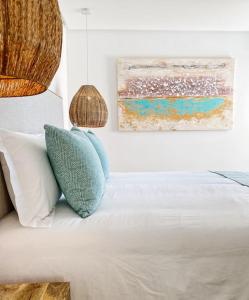 a bedroom with a bed with pillows and a painting at Front Sea Apartment Quarteira in Quarteira