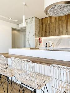 a kitchen with a bar with chairs and a counter at Front Sea Apartment Quarteira in Quarteira