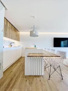 a kitchen with a table and chairs in a room at Front Sea Apartment Quarteira in Quarteira