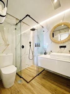a bathroom with a shower and a toilet and a sink at Front Sea Apartment Quarteira in Quarteira