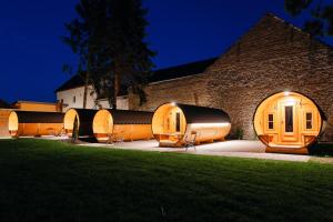 un bâtiment avec un groupe de chaises à l'extérieur la nuit dans l'établissement Urige Schlaffässer im Winzergarten inklusive Weinprobe, à Bockenheim