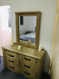 a wooden dresser with a mirror on top of it at sultan Qaboos city مدينة السلطان قابوس in Muscat