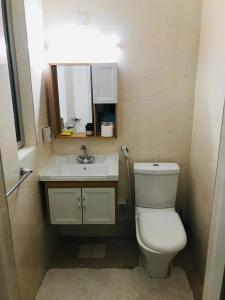 Łazienka z białą toaletą i umywalką w obiekcie sultan Qaboos city مدينة السلطان قابوس w Maskacie