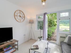 a living room with a large window and a clock at 38 Clyffe Pypard in Swindon