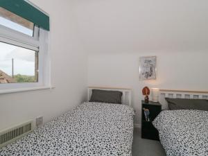 a bedroom with two beds and a window at 38 Clyffe Pypard in Swindon