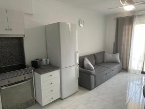 a kitchen with a refrigerator and a couch in a room at Castle Harbour Home in Los Cristianos