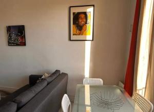 a living room with a couch and a glass table at Chez Marie - 4p - Proche Paris - Metro 8 in Maisons-Alfort