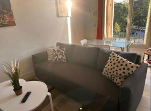 a living room with a couch and a table at Chez Marie - 4p - Proche Paris - Metro 8 in Maisons-Alfort +2 photos