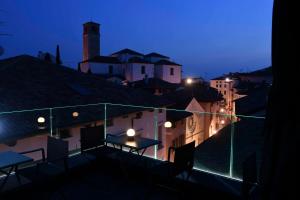 Habitación con vistas a la ciudad por la noche y mesa en el balcón. en Panorama Hotel Friuli - Boutique Hotel, en San Daniele del Friuli