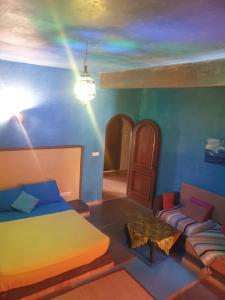 ein Schlafzimmer mit einem Bett, einem Sofa und einem Tisch in der Unterkunft Atlas Tigmi in Ourika