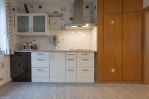 uma cozinha com armários brancos e uma porta de madeira em Privat-Pension-Doemens em Aachen