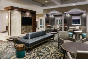 vestíbulo con sofá, mesas y sillas en Residence Inn by Marriott Charleston North/Ashley Phosphate, en Charleston