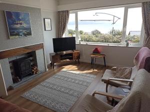 a living room with a fireplace and a television at Dubrovnik in Criccieth