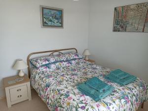 uma cama com duas almofadas num quarto em Dubrovnik em Criccieth