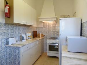 a kitchen with white cabinets and a white refrigerator at Casa Katarina in Luz