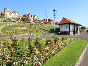 un jardin avec des fleurs devant un immeuble dans l'établissement The Corner House, à Weymouth