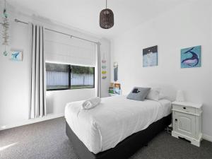 een witte slaapkamer met een bed en een raam bij Whale Tails Augusta - stylishly modern in the town of Augusta in Augusta