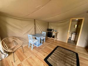 um quarto com uma mesa e cadeiras numa tenda em Parque dos Monges em Alcobaça