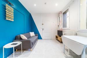 - un salon avec un canapé et un mur bleu dans l'établissement Le petit Venise cosy 2 pers patio et place de parking Villeurbanne, à Villeurbanne