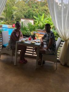 a man and a woman sitting at a table at Minah Bungalows in Nungwi