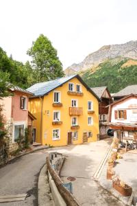 ein gelbes Gebäude am Straßenrand in der Unterkunft Le Milan Royal - Montmin in Montmin