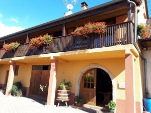 a building with a balcony with flowers on it at Chambres d'Hôtes Arnold in Dambach-la-Ville