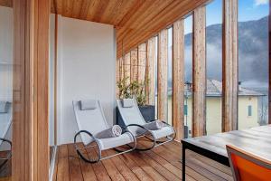 a room with two chairs and a table on a balcony at LUNALO' DOLOMITI eco design apartment in Cultura