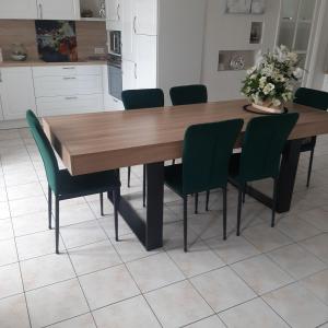 a kitchen with a wooden table with green chairs at chambres d'hotes REGINE in La Gouesnière