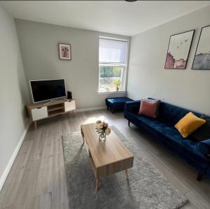 een woonkamer met een blauwe bank en een salontafel bij Stunning 2 Bedroom River View Apartment in Perth