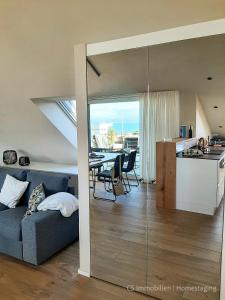 a living room and kitchen with a couch and a table at Designerloft See in Immenstaad am Bodensee
