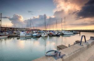 a group of boats docked in a marina at sunset at Lux Double Bed Studio by town & beach in Ryde