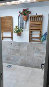 a bathroom with two chairs and a window and flowers at Casa Mejías, excelente localización, cerca de los principales puntos turísticos de Antequera in Antequera