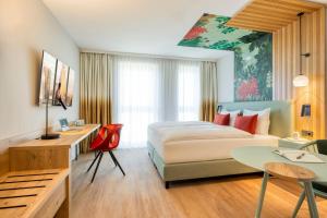 a hotel room with a bed and a desk at Citadines Danube Vienna in Vienna +34 photos