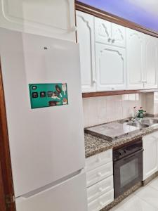 cocina con armarios blancos y nevera blanca en Apartamento San Agustín - Alojamientos El Duque, en Córdoba