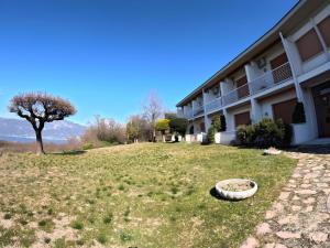 un bâtiment avec une cour herbeuse à côté d'un bâtiment dans l'établissement Garda Panoramic House, à Torri del Benaco