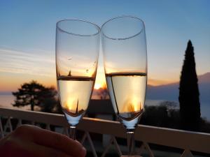 - deux verres de vin au coucher du soleil en arrière-plan dans l'établissement Garda Panoramic House, à Torri del Benaco