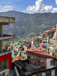 a view of a city with buildings and mountains at Hotel Gajraj in Gangtok