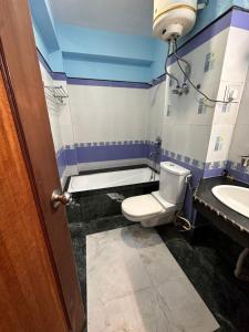 a bathroom with a toilet and a sink at Hotel Gajraj in Gangtok