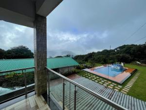 a view from the balcony of a house with a swimming pool at D-LITE COTTAGE in Mahabaleshwar