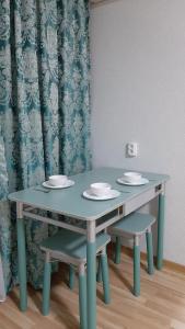 una mesa con dos sillas y una mesa con platos. en 2-х комнатная квартира, en Almaty