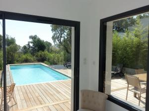 vistas desde una puerta corredera de cristal de una piscina en Apartment Villa Kalliste by Interhome, en Favone