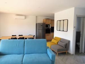 a living room with a blue couch and a kitchen at Apartment Villa Kalliste by Interhome in Favone
